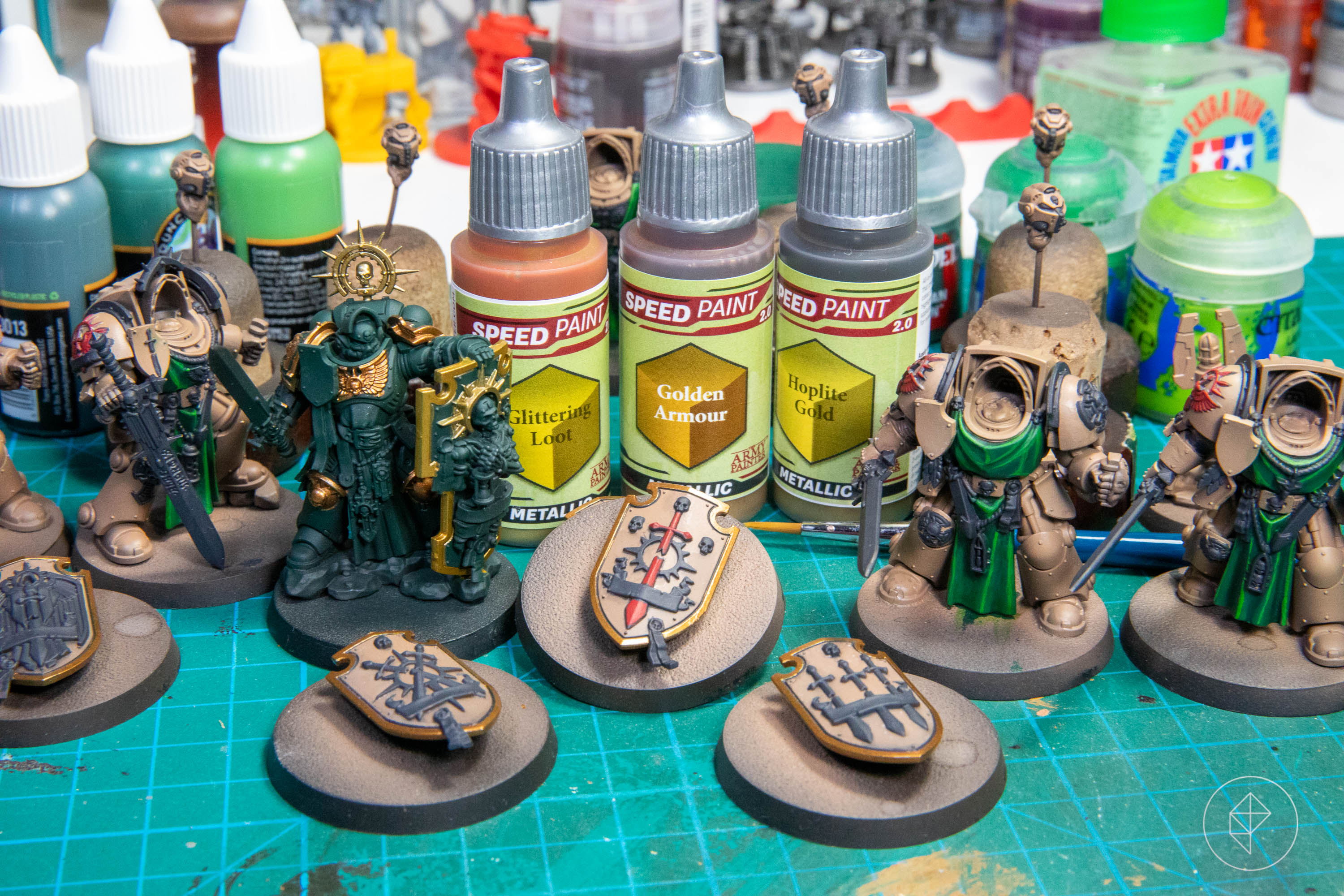 Several miniatures of the Dark Angels Deathwing Company ready for metallics. They’re sitting next to three bottles of The Army Painter paint.