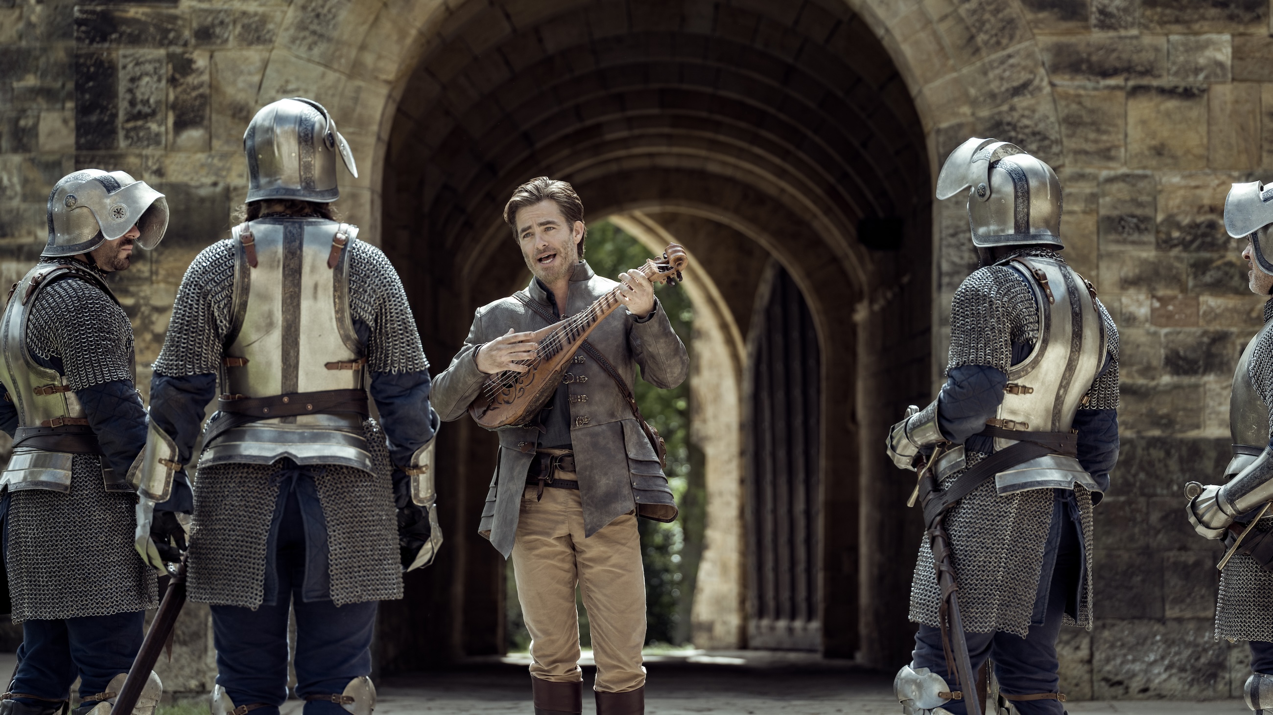 Chris Pine as Edgin the bard, playing his lute to an audience of suspicious guards in Dungeons and Dragons: Honor Among Thieves.