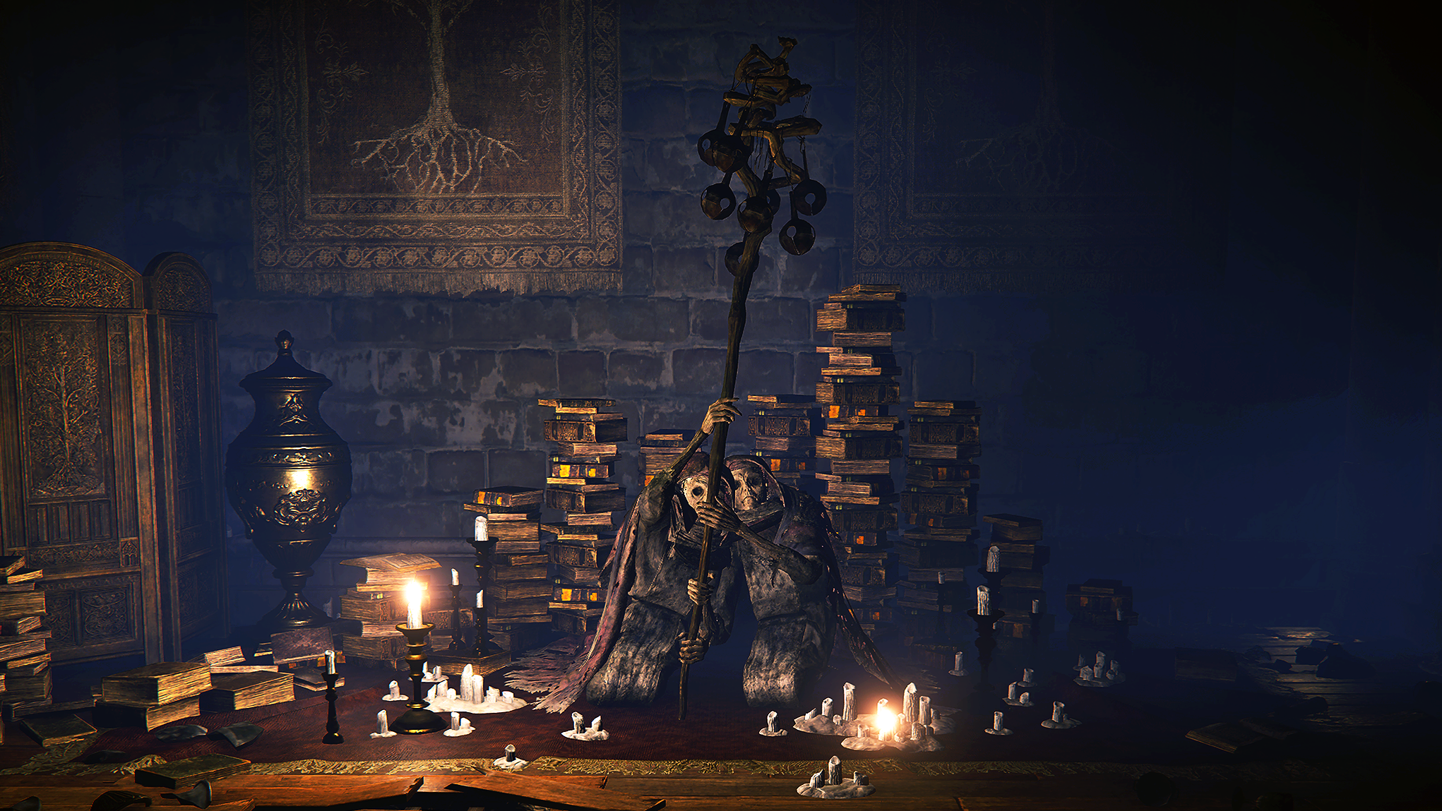 A figure in a cloak wielding a staff sits in front of books in a candlelit room collecting bell bearings in Elden Ring.